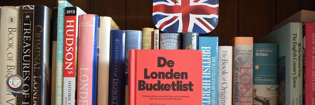 Boekenplank met diverse boeken, waaronder De Londen Bucketlist, met Union Jack vlag en houten achtergrond.